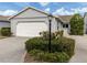 Exterior view of a single story home with a garage and landscaped front yard at 703 Ironwood Dr # 114, Venice, FL 34292
