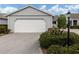 Attached garage with driveway and landscaping at 703 Ironwood Dr # 114, Venice, FL 34292