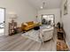 Bright living room with a mustard sofa, a neutral armchair, and hardwood floors at 703 Ironwood Dr # 114, Venice, FL 34292