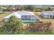 An aerial view of the home featuring a screened-in pool, landscaping, and mature trees at 7321 Teaberry St, Englewood, FL 34224