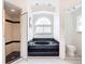 Luxurious bathroom featuring a stand-alone shower and a deep soaking tub beneath a large window at 7321 Teaberry St, Englewood, FL 34224