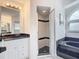 Bathroom with white vanity, soaking tub, and walk-in shower with tile and glass door at 7321 Teaberry St, Englewood, FL 34224