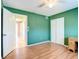 Bedroom with hardwood floors, a ceiling fan, green walls, and a closet at 7321 Teaberry St, Englewood, FL 34224