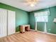 Bedroom with hardwood floors, a ceiling fan, green walls, and a closet at 7321 Teaberry St, Englewood, FL 34224