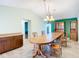 Elegant dining room with a large wooden table, chandelier, and green accent wall for memorable dining moments at 7321 Teaberry St, Englewood, FL 34224