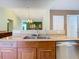 Kitchen view showcases stainless steel dishwasher, double sink, and wooden cabinets, merging functionality with style at 7321 Teaberry St, Englewood, FL 34224