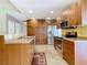 Open-concept kitchen with stainless steel appliances, wooden cabinets, and an island for culinary excellence and convenience at 7321 Teaberry St, Englewood, FL 34224