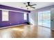 Bright main bedroom features hardwood floors, a modern ceiling fan, and a sliding glass door at 7321 Teaberry St, Englewood, FL 34224