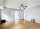 A serene main bedroom featuring hardwood floors, ceiling fan, and bright sliding glass doors at 7321 Teaberry St, Englewood, FL 34224