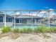 Backyard view of the home's screened-in pool surrounded by well-kept landscaping at 7321 Teaberry St, Englewood, FL 34224