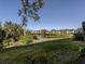 Scenic backyard view overlooking a tranquil lake with lush greenery and manicured landscaping at 801 Waterside Dr # 102, Venice, FL 34285