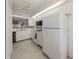 Bright kitchen with white appliances and tile floor at 801 Waterside Dr # 102, Venice, FL 34285