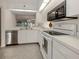 Modern kitchen with white cabinetry, stainless steel appliances, and a view to the dining area at 801 Waterside Dr # 102, Venice, FL 34285