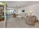 Living room with comfy seating, coffee table, and sliding glass doors at 801 Waterside Dr # 102, Venice, FL 34285