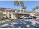 Exterior view of the building with covered parking and multiple cars parked underneath palm trees at 801 Waterside Dr # 102, Venice, FL 34285
