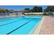 Community pool with multiple lap lanes, lounge chairs, and umbrellas for relaxation at 801 Waterside Dr # 102, Venice, FL 34285