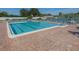 Community pool with brick patio and lounge chairs at 801 Waterside Dr # 102, Venice, FL 34285