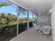 Bright sunroom with glass enclosure, table and chairs, and view of water at 801 Waterside Dr # 102, Venice, FL 34285