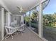 Relaxing sunroom with glass windows, a ceiling fan, and furniture; laundry closet visible at 801 Waterside Dr # 102, Venice, FL 34285