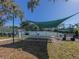 Community tennis court with shade structure and seating at 801 Waterside Dr # 102, Venice, FL 34285