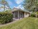 Backyard view showing screened porch and lawn at 826 Bayport Cir, Venice, FL 34292