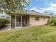 Backyard view showing screened porch and lawn at 826 Bayport Cir, Venice, FL 34292