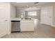 Kitchen with stainless steel dishwasher and view into living room at 826 Bayport Cir, Venice, FL 34292