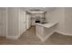 Bright kitchen features white cabinets, laminate flooring, and a breakfast bar at 826 Bayport Cir, Venice, FL 34292