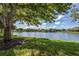Scenic lakefront property with lush landscaping and mature trees at 826 Bayport Cir, Venice, FL 34292