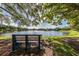 Relaxing lakeside bench under shady trees, peaceful setting at 826 Bayport Cir, Venice, FL 34292