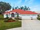 Single-story home with red tile roof, white walls, and a two-car garage at 1035 Beckley Cir, Venice, FL 34292