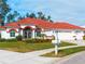 Single-story home with red tile roof, white walls, and a three-car garage at 1035 Beckley Cir, Venice, FL 34292