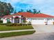 Single story home with red tile roof, white walls, and a three-car garage at 1035 Beckley Cir, Venice, FL 34292