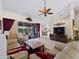 Open living space with tan couches, a large TV, and pool access at 1035 Beckley Cir, Venice, FL 34292