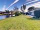 Home's back overlooks a pond, featuring a patio and grassy yard at 104 Woodingham Dr, Venice, FL 34292