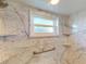 Updated bathroom with marble shower, grab bars, and a window at 104 Woodingham Dr, Venice, FL 34292