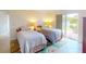 Guest bedroom with two twin beds and backyard access at 104 Woodingham Dr, Venice, FL 34292