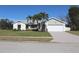 Single-story house with a white garage door and palm trees at 104 Woodingham Dr, Venice, FL 34292