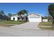 Single-story house with a white garage door and palm trees in the front yard at 104 Woodingham Dr, Venice, FL 34292
