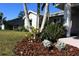Landscaped front yard with palm trees and mulch at 104 Woodingham Dr, Venice, FL 34292