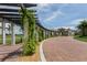 Community entrance with a curved brick road and pergola at 10792 Tarflower Dr # 202, Venice, FL 34293