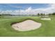 Sand traps on the golf course with lake and homes in background at 10792 Tarflower Dr # 202, Venice, FL 34293