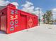 Red shipping container building with signage at 10792 Tarflower Dr # 202, Venice, FL 34293
