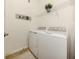 Bright laundry room with washer, dryer, and shelving at 10792 Tarflower Dr # 202, Venice, FL 34293