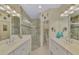 Double vanity bathroom with walk-in shower and marble tile at 11409 Okaloosa Dr, Venice, FL 34293