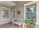 Front entry with bench, potted plants, and sunburst wall decor at 11409 Okaloosa Dr, Venice, FL 34293