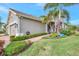 Tan house with tile roof, landscaping, and a three-car garage at 11409 Okaloosa Dr, Venice, FL 34293