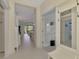 Bright hallway with entry to other rooms, and white bench at 11409 Okaloosa Dr, Venice, FL 34293