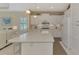 Kitchen island with seating, white cabinets, and granite countertops at 11409 Okaloosa Dr, Venice, FL 34293