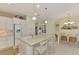 Open concept kitchen with island, white cabinets, and adjacent dining area at 11409 Okaloosa Dr, Venice, FL 34293